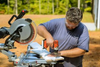Carpentier utilisant une perceuse visseuse Milwaukee sur des planches en bois