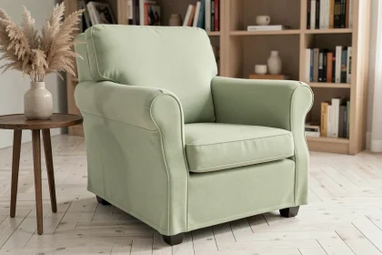 Housse extensible vert sauge sur fauteuil club dans un salon moderne avec parquet en chêne blanchi et décoration naturelle