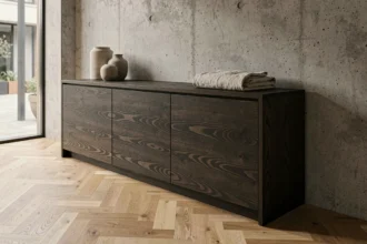 Meuble design en bois exotique wengé dans un salon contemporain aux murs en béton brut, tendances déco 2026