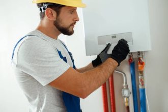 Technicien réglant une chaudière à gaz pour le chauffage et l'eau chaude